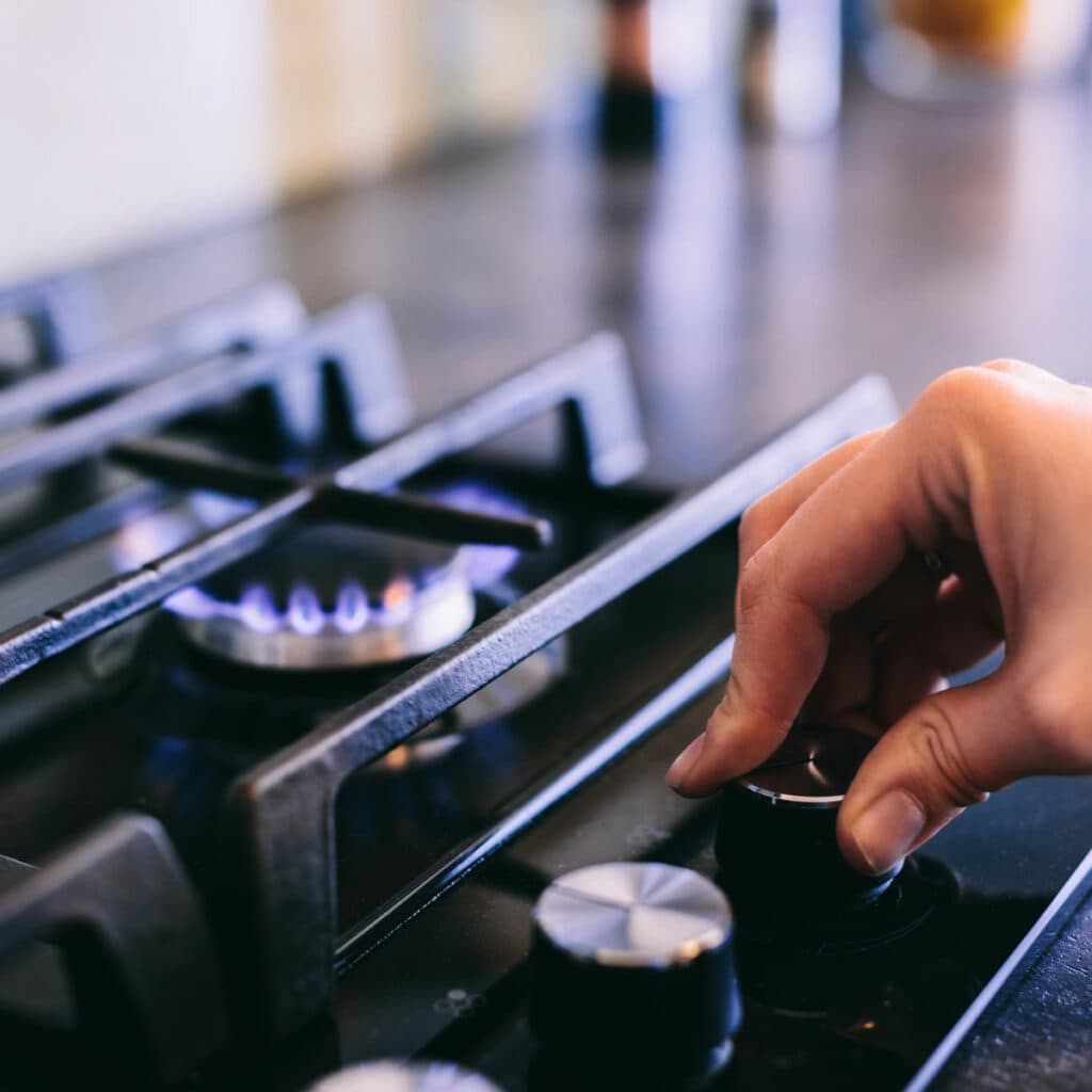 person turning on gas stove